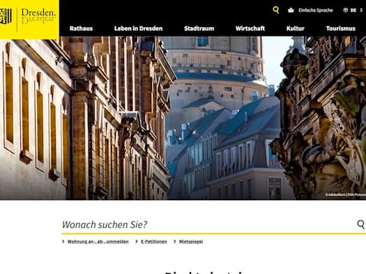 Screenshot der Startseite von dresden.de. Oben links ist das gelbe Dresden-Logo zu sehen, darunter ein Headerbild der historischen Altstadt und die Suchleiste „Wonach suchen Sie?“ mit Verlinkungen wie Wohnungsanmeldung und Mietspiegel.