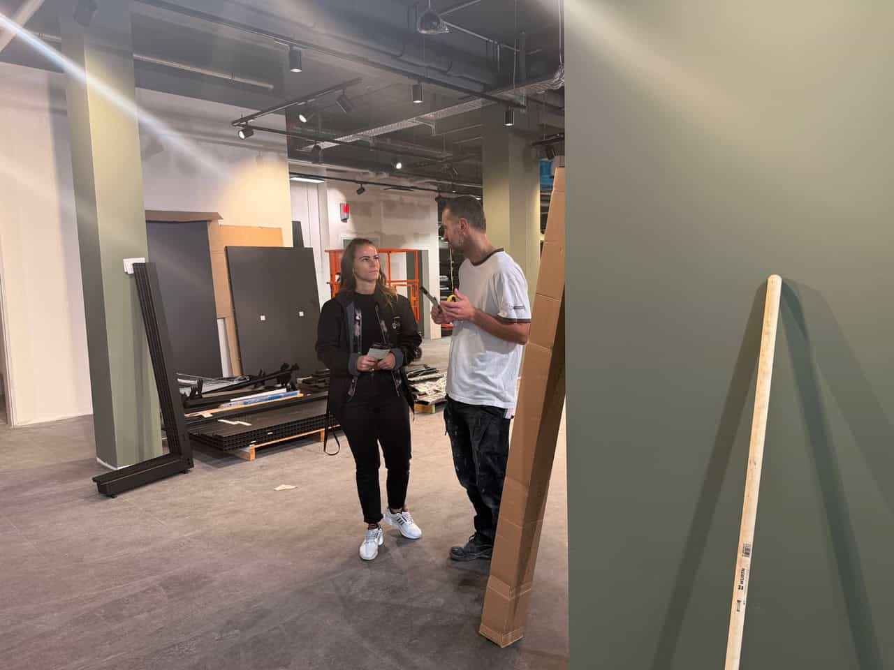 Michaela Felsch und Bauleiter Maik Pasche beim Innenausbau des Edeka-Marktes Dresden Michaela Felsch und Bauleiter Maik Pasche stehen im noch unfertigen Verkaufsraum des Supermarktes zwischen grünen Säulen, Regalbauteilen und Baumaterialien.