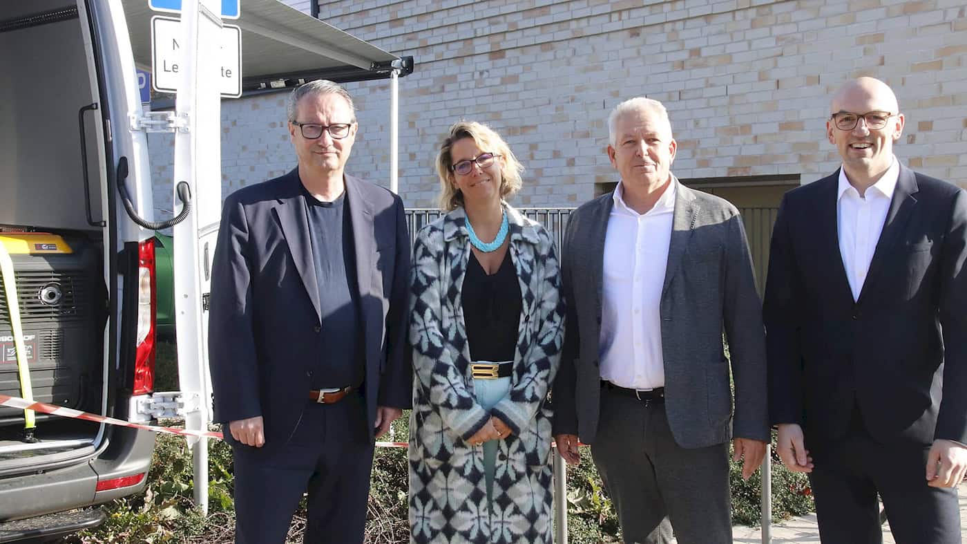 Dresden: Auftakt zur Graffiti-Beseitigung per Laser an Schule auf Stauffenbergallee Vier Personen stehen vor einer Klinkerwand im Freien: v.l.n.r. Bildungsbürgermeister Jan Donhauser, Schulleiterin Miriam Bankert sowie die SRD-Geschäftsführer Alf Schwarten und Michael Hamacher. Links steht das Einsatzfahrzeug mit Stromaggregat.