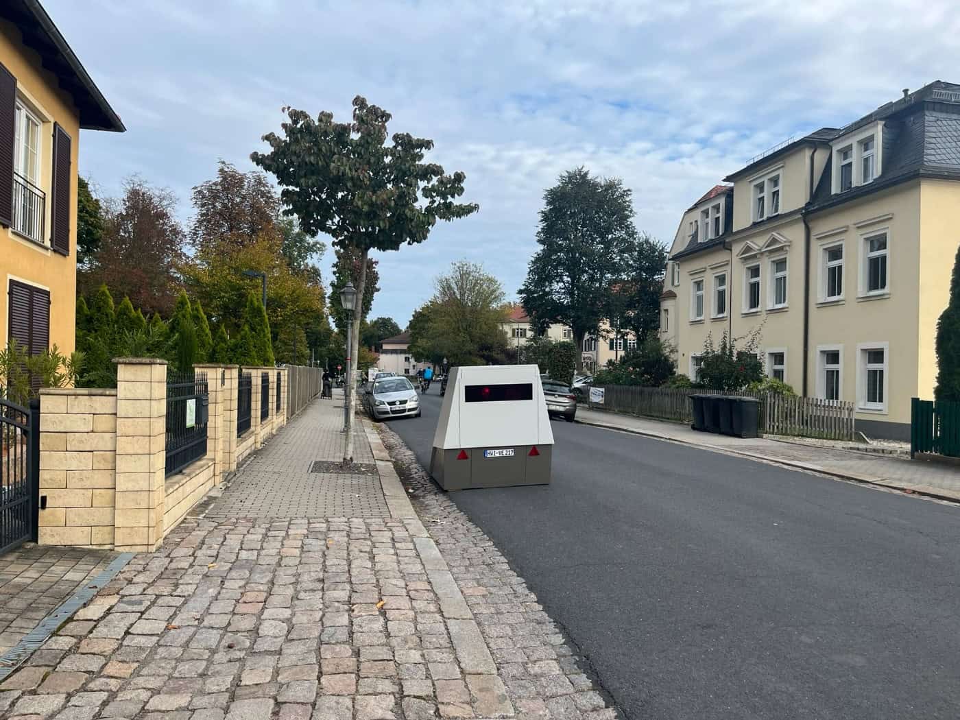 Blick auf den grau-weißen Enforcement Trailer (Blitzer-Anhänger) mit dem Kennzeichen HWI-VE 217, der auf der Schützenhofstraße in Dresden-Trachau mit Sicherheitsabstand wegen des Kopfsteinpflasters platziert ist.