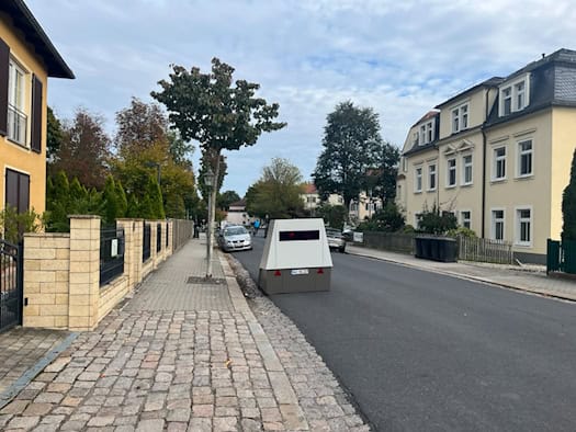 Blick auf den grau-weißen Enforcement Trailer (Blitzer-Anhänger) mit dem Kennzeichen HWI-VE 217, der auf der Schützenhofstraße in Dresden-Trachau mit Sicherheitsabstand wegen des Kopfsteinpflasters platziert ist.