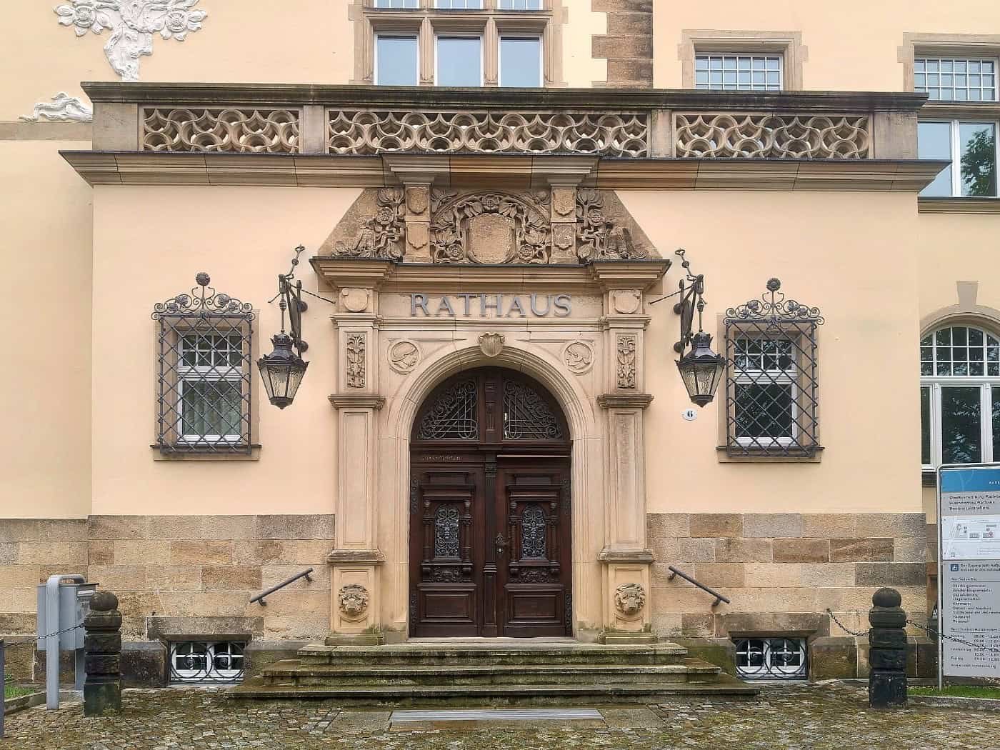 Eingangsportal des Radebeuler Rathauses mit der Inschrift „Rathaus“ über einer verzierten Holztür