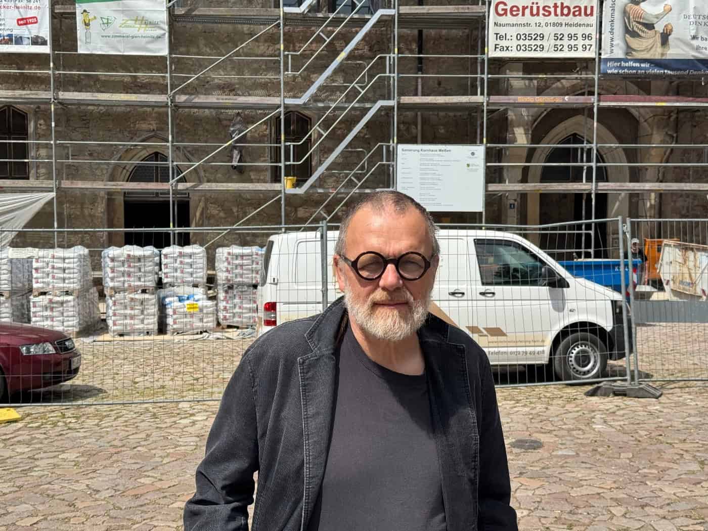 Langgestrecktes historisches Kornhaus mit steilem Ziegeldach, Dachgauben und Treppenturm am gepflasterten Domplatz in Meißen