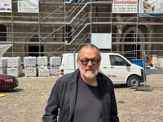 Langgestrecktes historisches Kornhaus mit steilem Ziegeldach, Dachgauben und Treppenturm am gepflasterten Domplatz in Meißen