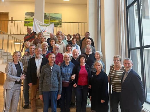Gruppe von Menschen steht auf einer Treppe im Sächsischen Landtag und hält ein Banner der Städtepartnerschaft Meißen und Vitry-sur-Seine.