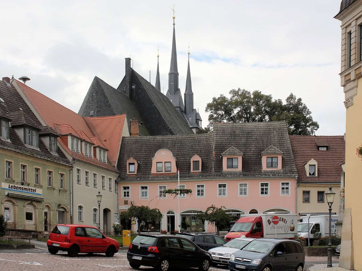 Marktplatz in Lommatzsch mit Häuserzeile und Kirchtürmen im Hintergrund