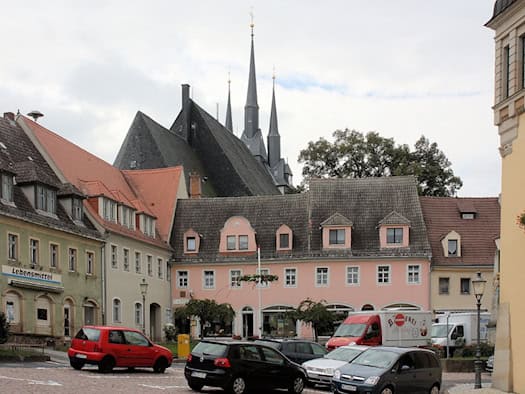 Marktplatz in Lommatzsch mit Häuserzeile und Kirchtürmen im Hintergrund