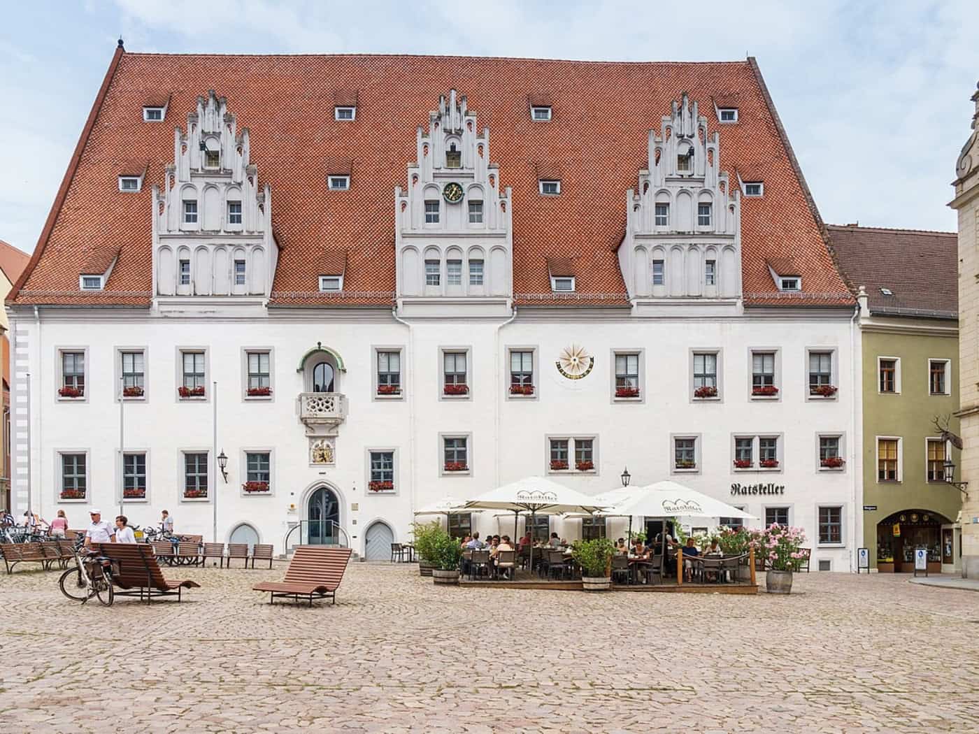 Frontansicht des Meißner Rathauses am Markt mit weißer Fassade, drei Ziergiebeln und rotem Ziegeldach.