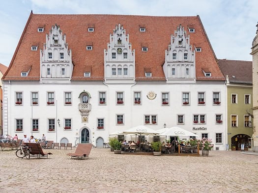 Frontansicht des Meißner Rathauses am Markt mit weißer Fassade, drei Ziergiebeln und rotem Ziegeldach.
