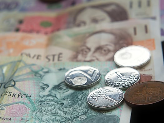 Sechs tschechische Kronenmünzen unterschiedlicher Größe nebeneinander auf einer hellen Fläche.