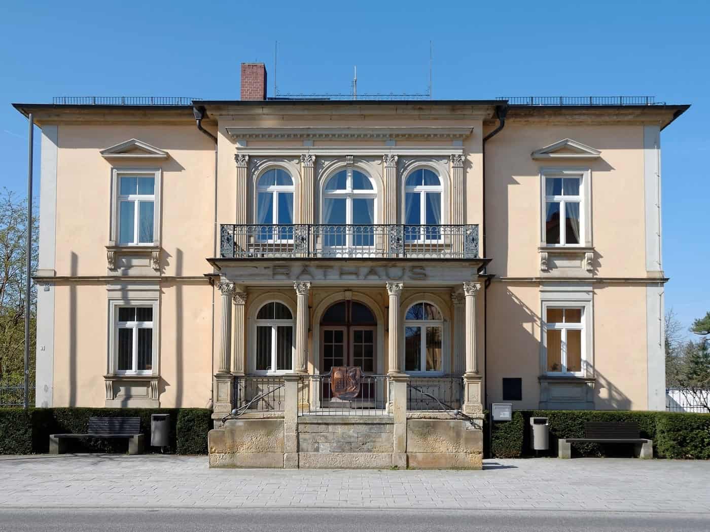 Zweistöckiges, hellgelbes Rathaus in Moritzburg mit Säulenportikus und Balkon, Schriftzug Rathaus über dem Eingang