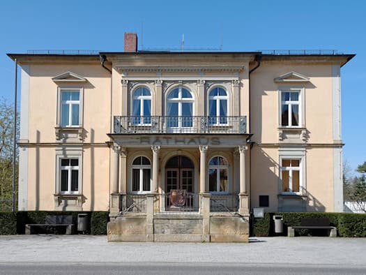 Zweistöckiges, hellgelbes Rathaus in Moritzburg mit Säulenportikus und Balkon, Schriftzug Rathaus über dem Eingang
