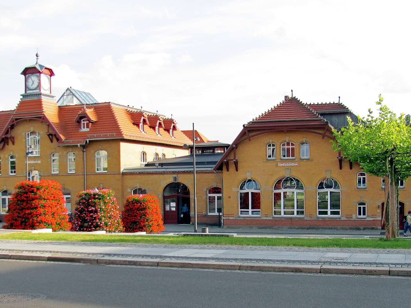 Gelbes Bahnhofsgebäude Radebeul Ost mit Uhrturm und roten Dächern