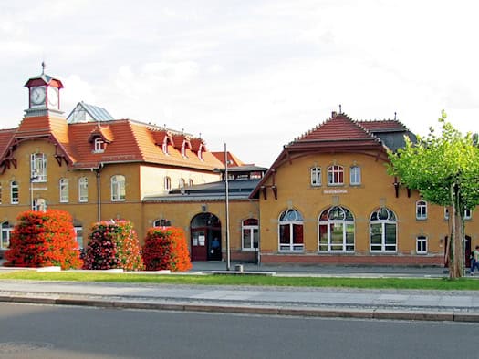 Gelbes Bahnhofsgebäude Radebeul Ost mit Uhrturm und roten Dächern