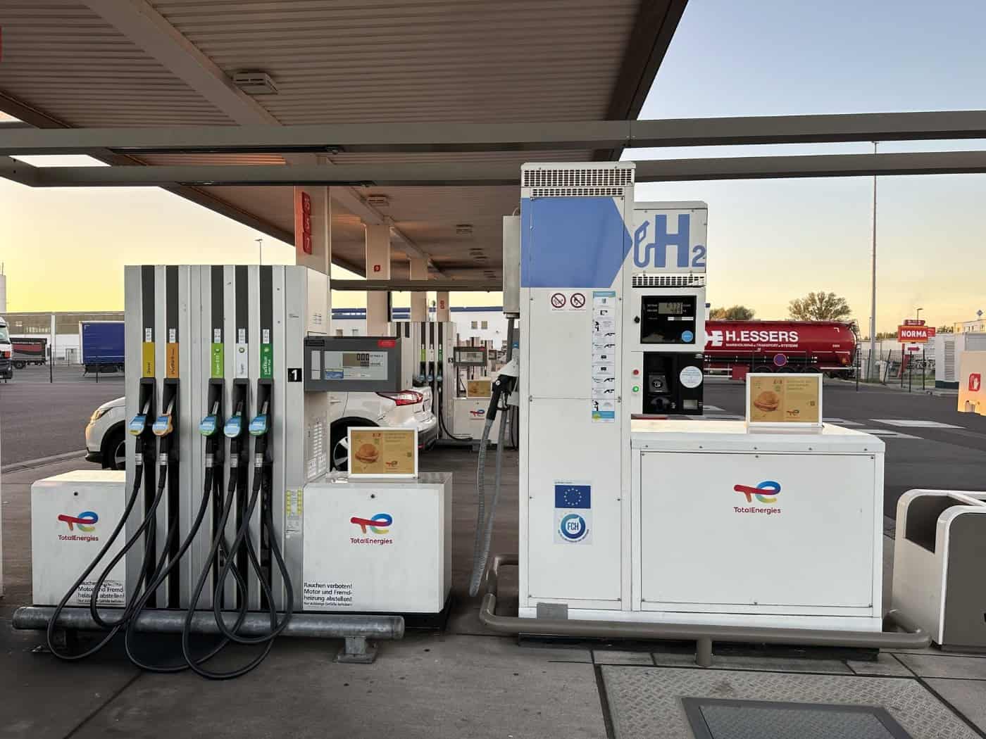 Wasserstoff-Zapfsäule mit H2-Schild neben herkömmlichen Zapfsäulen an einer Tankstelle