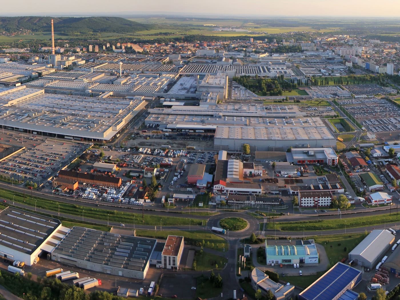 Luftaufnahme des weitläufigen Škoda-Werks in Mladá Boleslav mit Produktionshallen, Parkplätzen und angrenzenden Wohngebäuden.