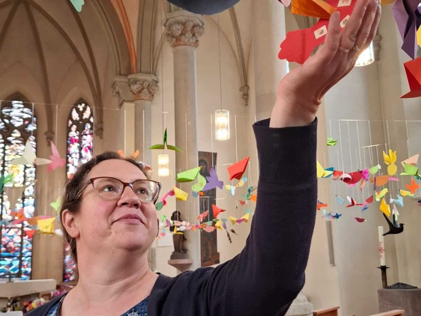 Bunte Papiervögel hängen an Fäden im Kirchenschiff der Meißner St.-Benno-Kirche