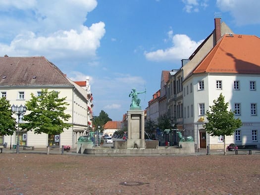 Hauptmarkt Großenhain mit Dianabrunnen und historischen Häusern bei blauem Himmel