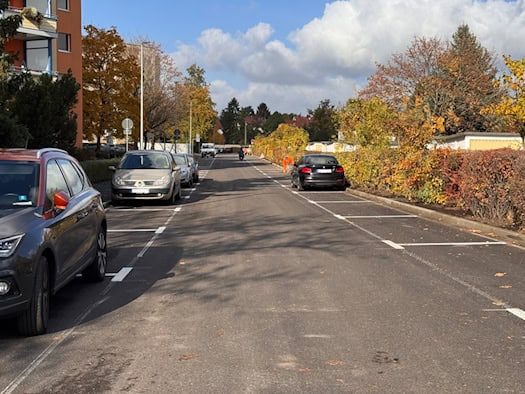Frisch sanierte Lößnitzstraße in Coswig mit neuer Fahrbahnmarkierung und parkenden Autos
