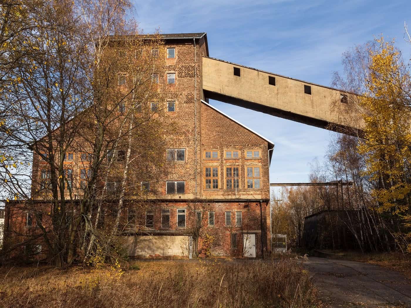Backsteingebäude des ehemaligen Davidschachts in Freiberg mit Förderbrücke im Herbst