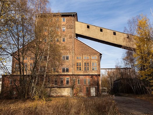 Backsteingebäude des ehemaligen Davidschachts in Freiberg mit Förderbrücke im Herbst