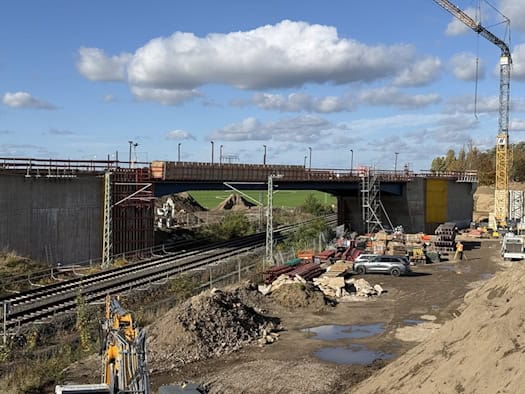 Neue Brücke der B 101 über die Bahnstrecke bei Großenhain, davor Gleise, Baumaterial und ein Kran