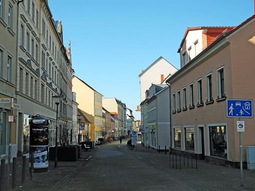 Fußgängerzone Hauptstraße in Riesa mit Altbauten und Geschäften bei blauem Himmel