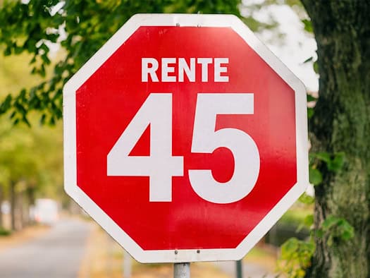 Rotes Stoppschild mit der Aufschrift „Rente 45“ an einer Allee