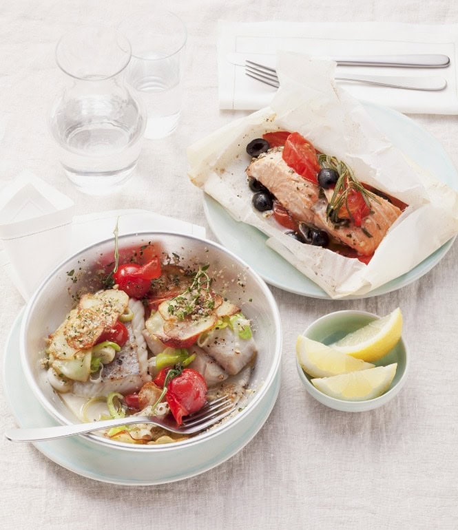 Gedeckter Tisch mit fertigem Gericht Lachs im Pergamentpapier