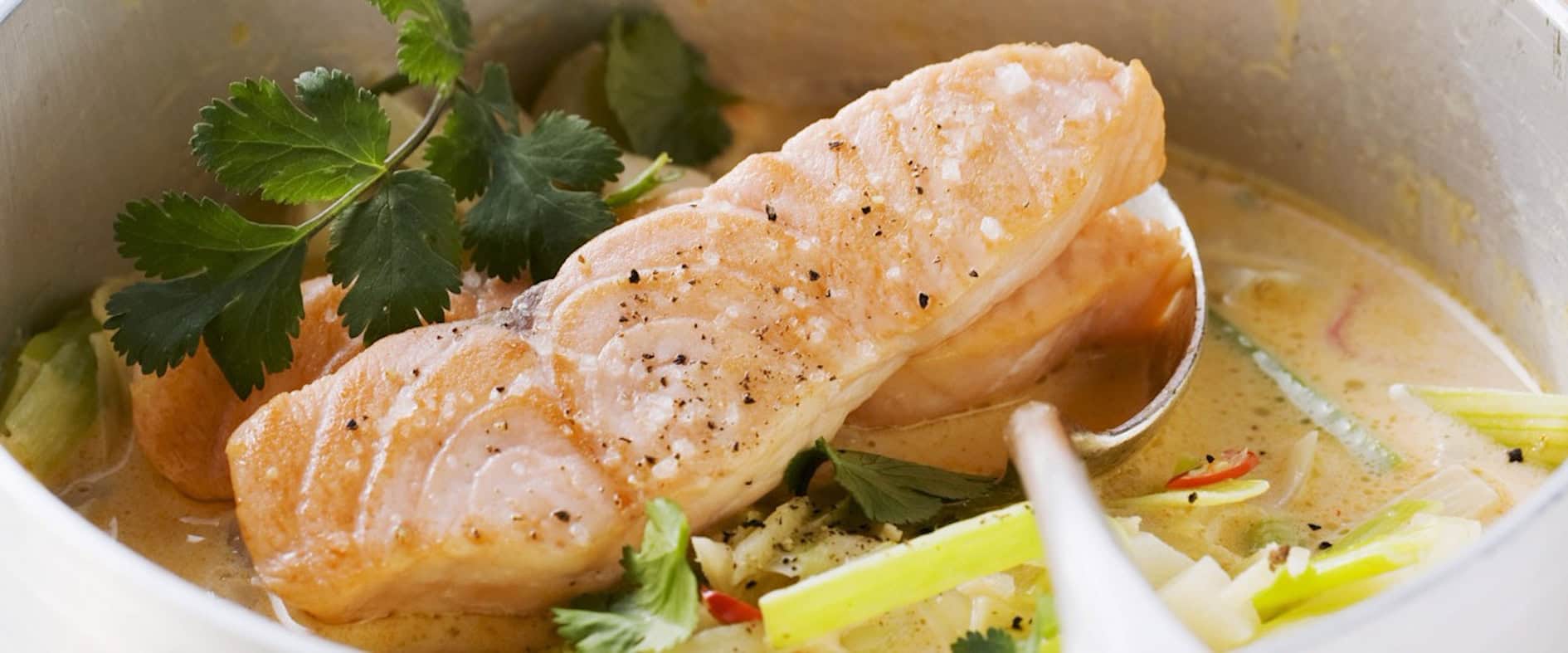 Zart gebratener Lachs auf würzigem Kokos-Gemüsecurry Fertiges Gericht Gemüsecurry mit Lachs