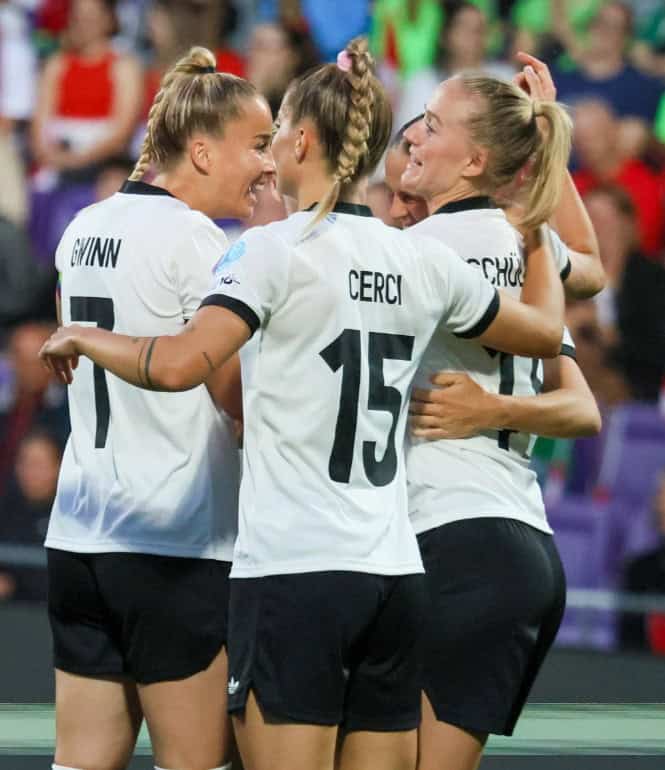 Spielerinnen der deutschen Frauen-Nationalmannschaft feiern gemeinsam ein Tor während eines EM-Spiels in weiß-schwarzen Trikots.
