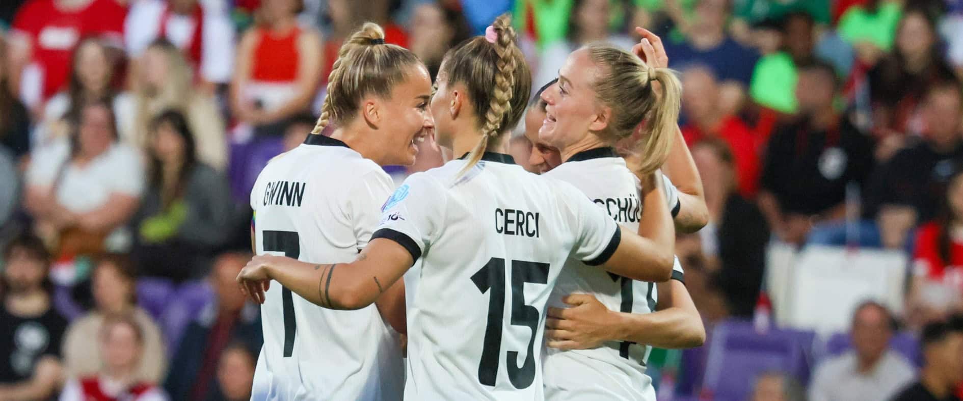 Spielerinnen der deutschen Frauen-Nationalmannschaft feiern gemeinsam ein Tor während eines EM-Spiels in weiß-schwarzen Trikots.