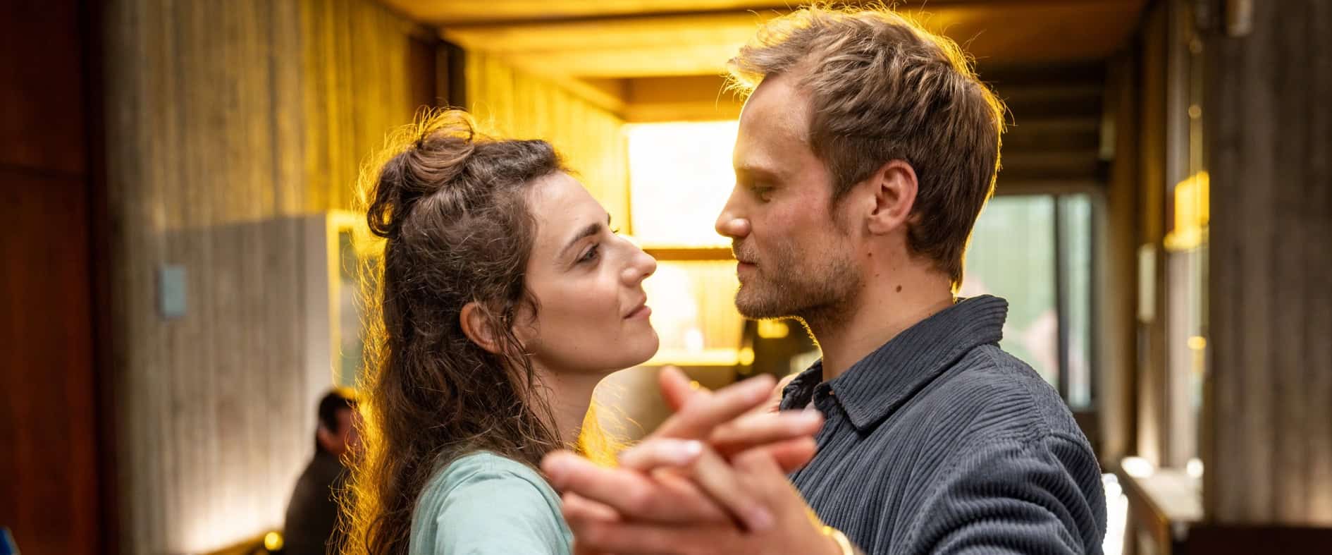 Ein Mann und eine Frau tanzen eng umschlungen in warmem Licht – Szene aus dem ARD-Film „Nächte vor Hochzeiten".