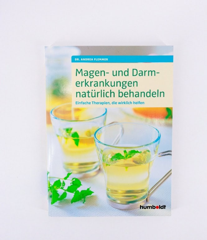 Buchcover des Ratgebers „Magen- und Darmerkrankungen natürlich behandeln“ von Dr. Andrea Flemmer mit zwei Gläsern Kräutertee und frischer Minze auf hellem Hintergrund.