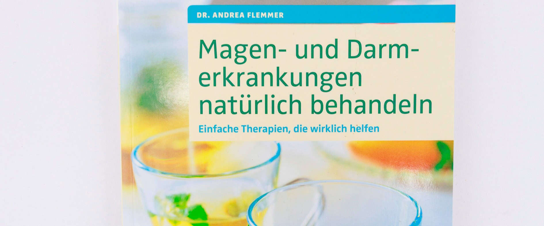 Buch-Verlosung: Gesundheitsratgeber von Dr. Andrea Flemmer gewinnen Buchcover des Ratgebers „Magen- und Darmerkrankungen natürlich behandeln“ von Dr. Andrea Flemmer mit zwei Gläsern Kräutertee und frischer Minze auf hellem Hintergrund.