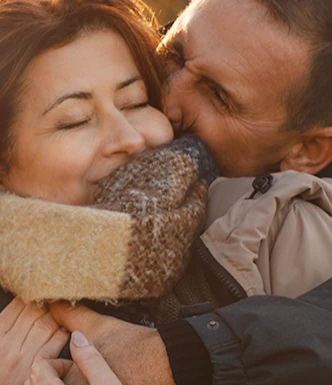 Glückliches Paar umarmt sich im herbstlichen Park – Symbol für Gelassenheit und Lebensfreude ab 50