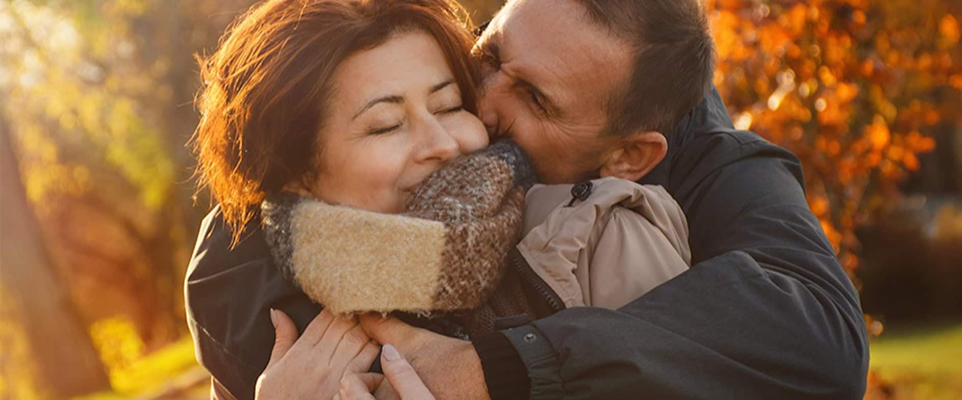 Glückliches Paar umarmt sich im herbstlichen Park – Symbol für Gelassenheit und Lebensfreude ab 50