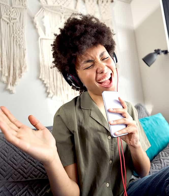 Person singt zu ihrer Lieblingsmusik und erlebt Glücksgefühle.