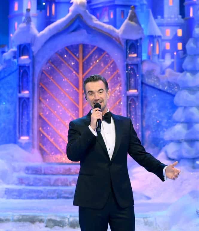 Moderator Florian Silbereisen in festlicher Bühne mit winterlicher Kulisse während einer großen TV-Weihnachtsshow.