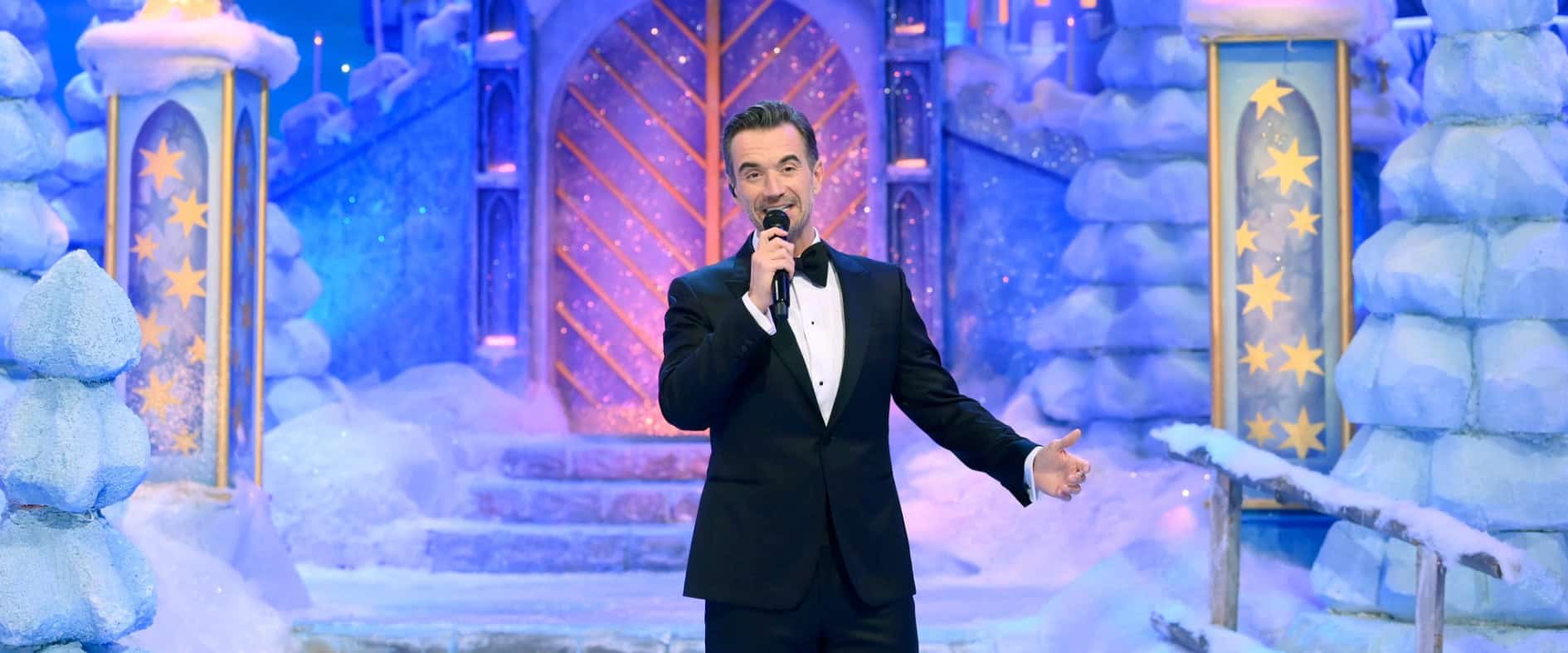 Moderator Florian Silbereisen in festlicher Bühne mit winterlicher Kulisse während einer großen TV-Weihnachtsshow.