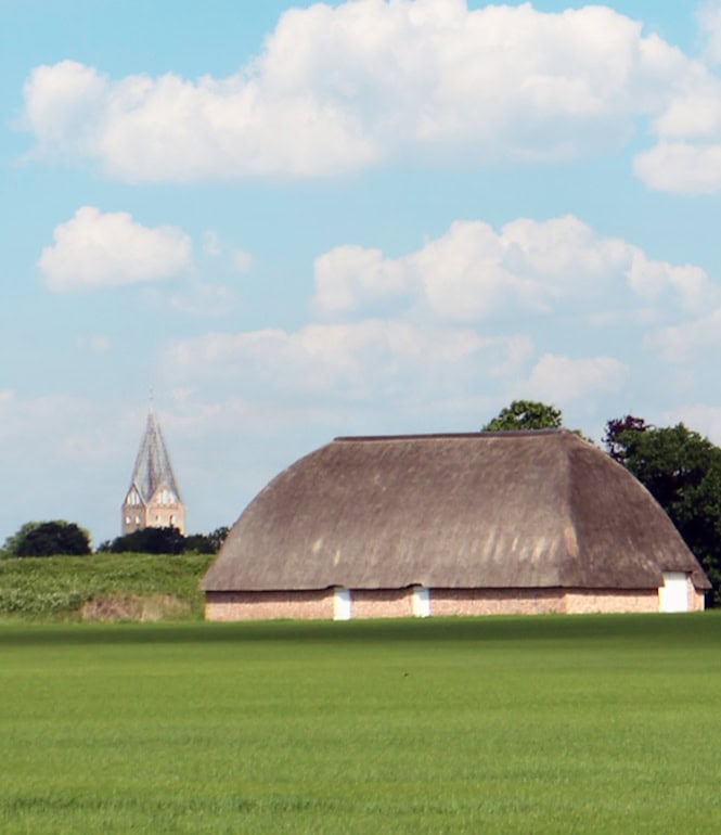 Blick auf Slotfelt-Scheune und Kirche von Møgeltønder entlang des Marskstien in Dänemark