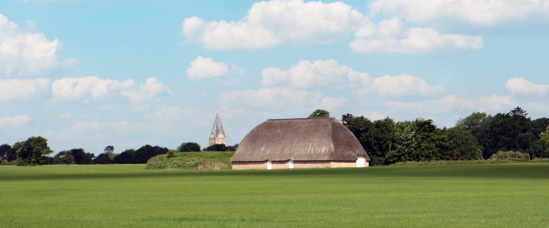 Blick auf Slotfelt-Scheune und Kirche von Møgeltønder entlang des Marskstien in Dänemark