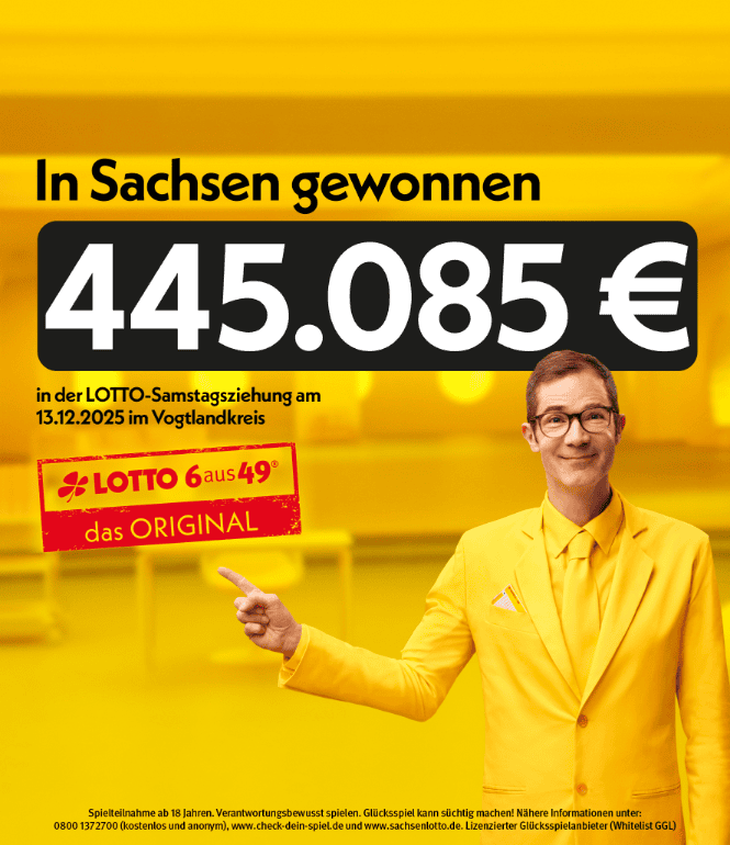 Ein freundlich lächelnder Mann in gelbem Anzug zeigt auf einen Gewinn von 445.085 Euro bei der LOTTO-Samstagsziehung am 13.12.2025 im Vogtlandkreis.