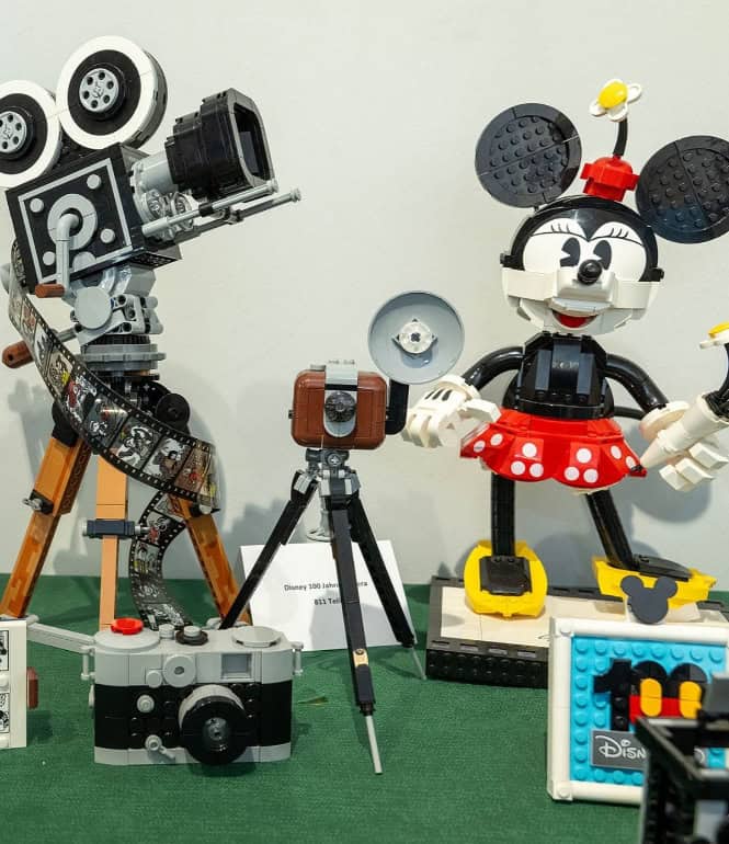 LEGO-Figuren von Micky Maus und Minnie Maus mit Kamera und Filmrolle in einer Ausstellung aus Klemmbausteinen