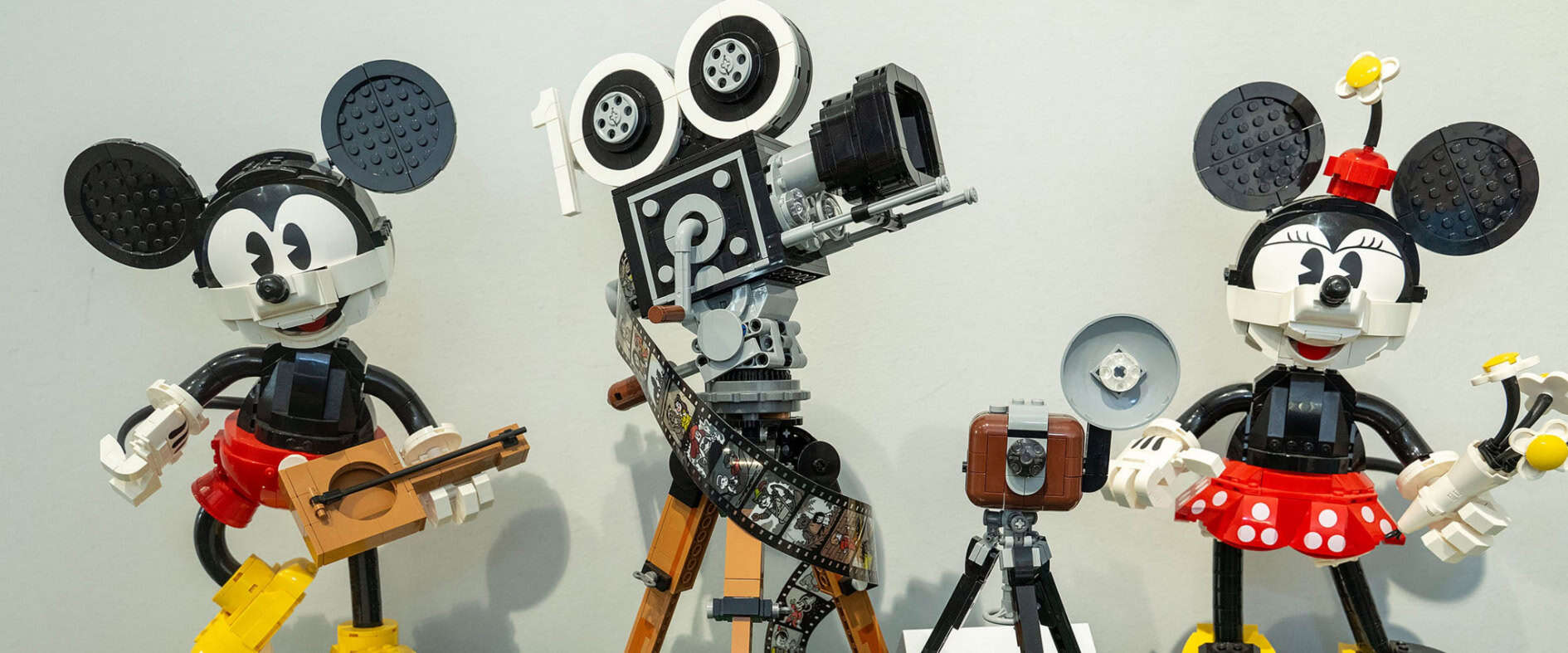 LEGO-Figuren von Micky Maus und Minnie Maus mit Kamera und Filmrolle in einer Ausstellung aus Klemmbausteinen
