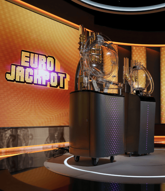 Ziehungsgeräte im Eurojackpot-Studio vor leuchtend gelbem Hintergrund mit Logo