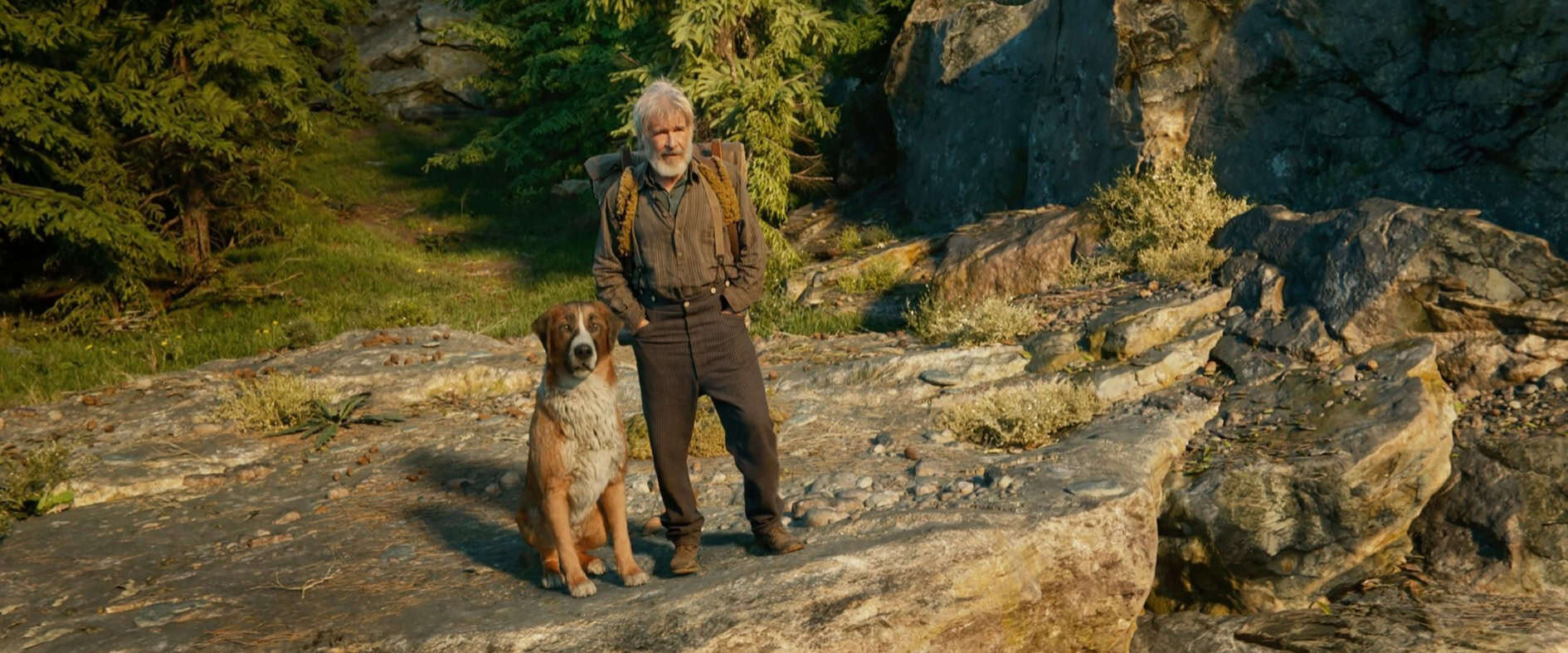 Ein Mann und ein Hund stehen auf einem Felsen in der Wildnis Alaskas – Szene aus „Ruf der Wildnis“.