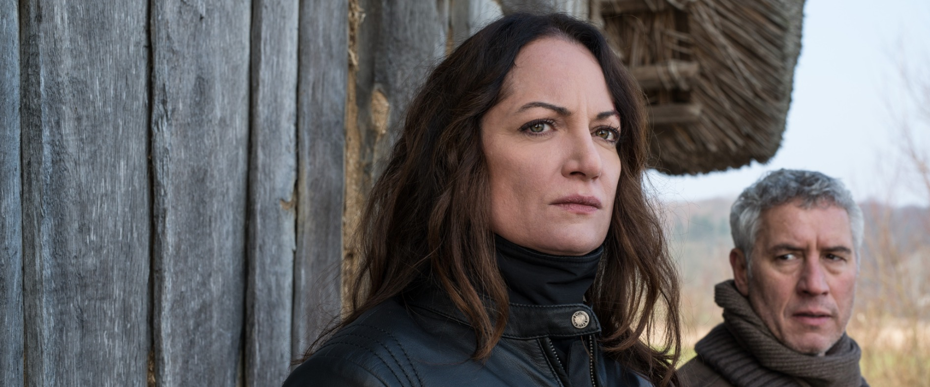 Natalia Wörner als Kriminalrätin Jana Winter vor einer Holzhütte, neben ihr ein Kollege, beide blicken angespannt in die Ferne