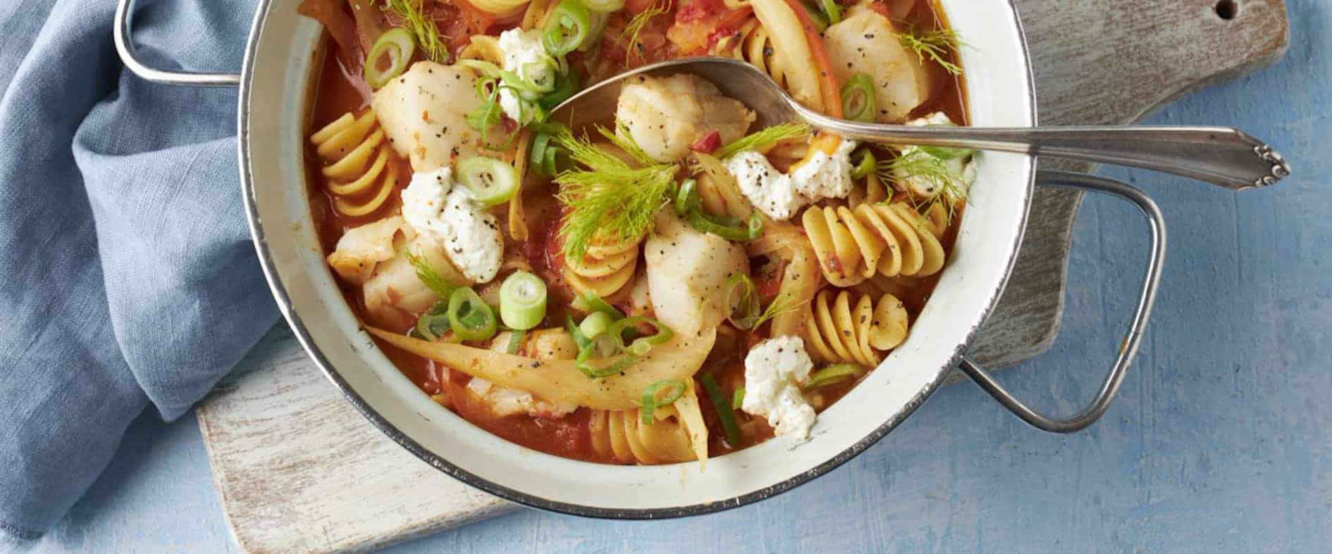 Sizilianische Fisch-Fusilli mit Fenchel, Tomaten und Burrata in einer Pfanne, garniert mit frischem Dill.