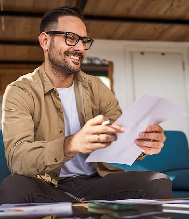 Lächelnder Mann liest einen Brief – ein Moment der Wertschätzung und des Glücks.